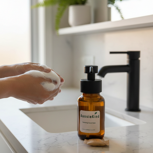 Person washing hands with AussieKind foaming hand soap in a minimal bathroom setting